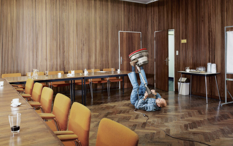 Man using floor polisher in conference room