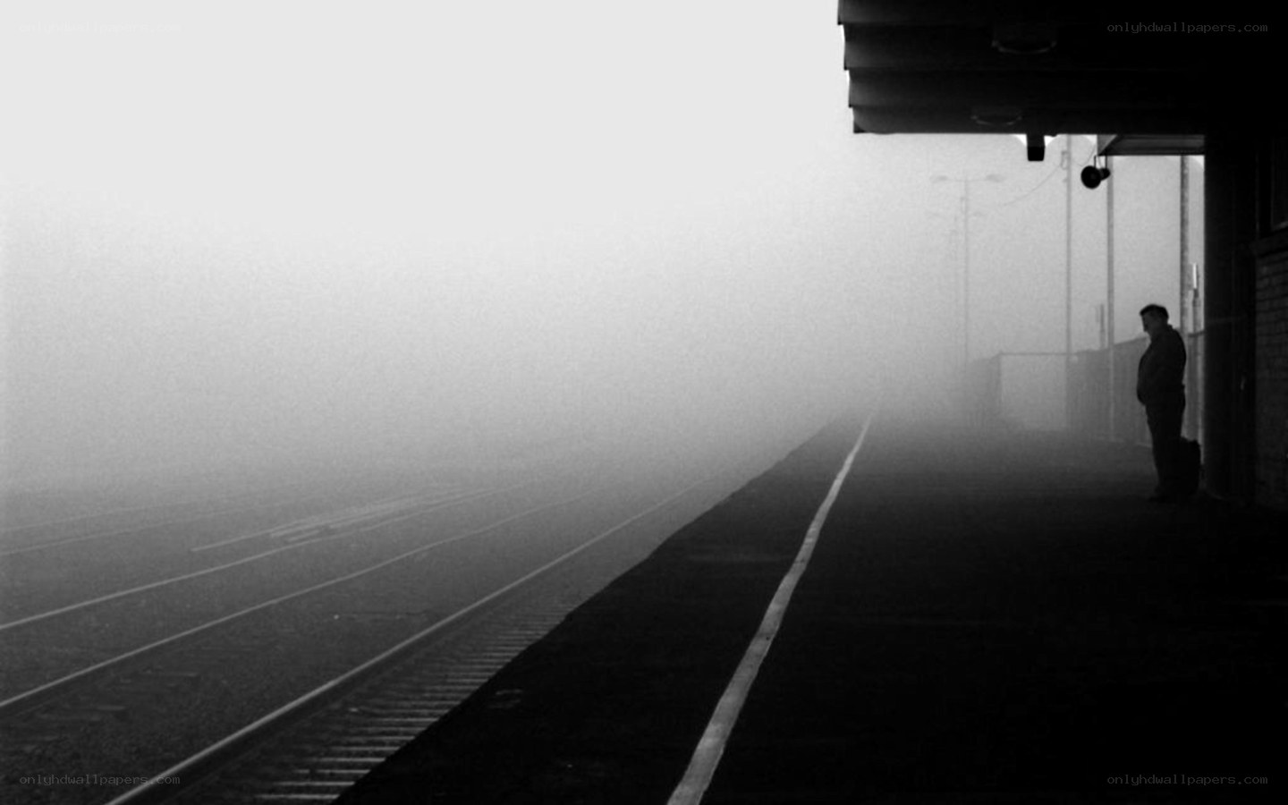Man waiting on foggy train platform