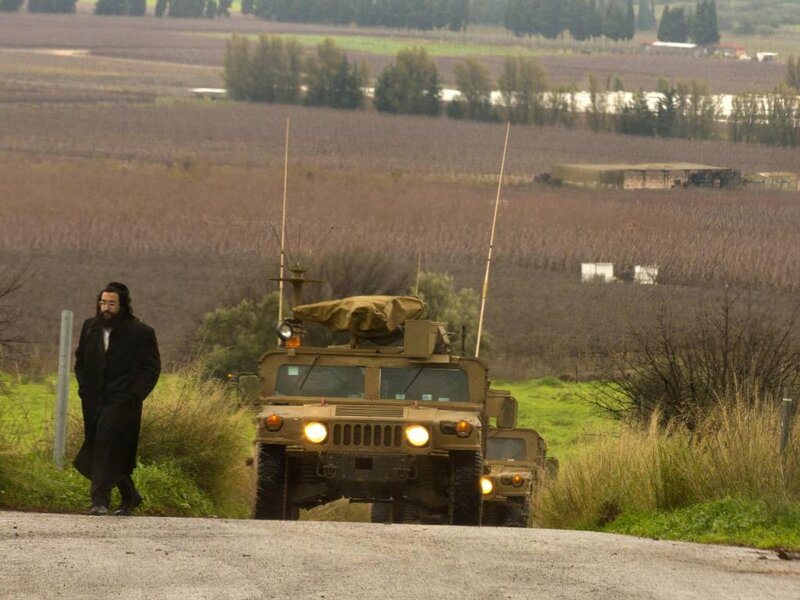 Man Walking Beside Military Vehicles
