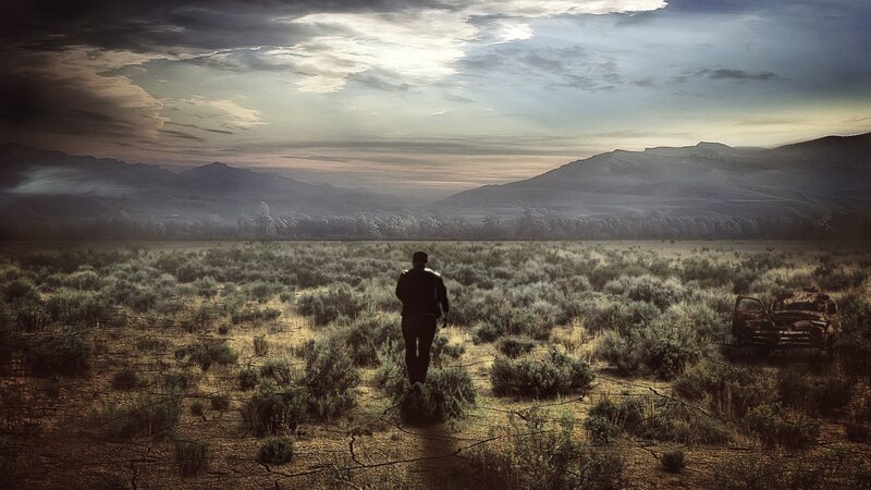man walking in a desert landscape