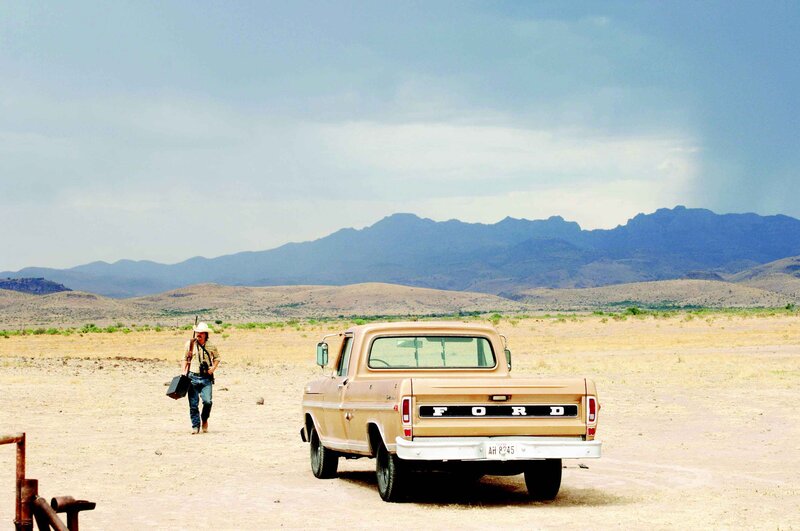 Man walking in desert with truck