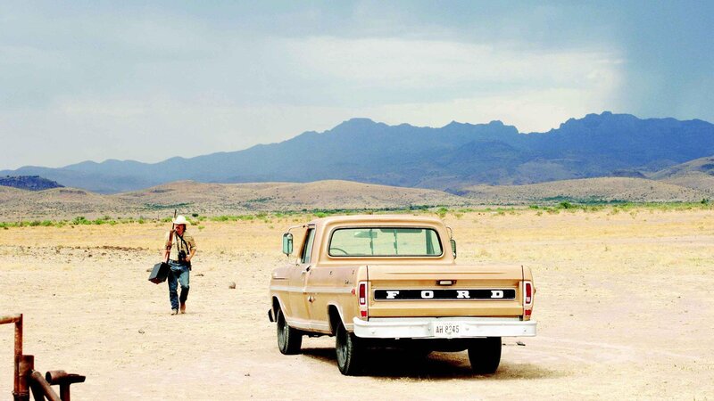 Man walking in desert with truck