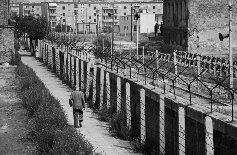 Man walking near a barbed wire fence