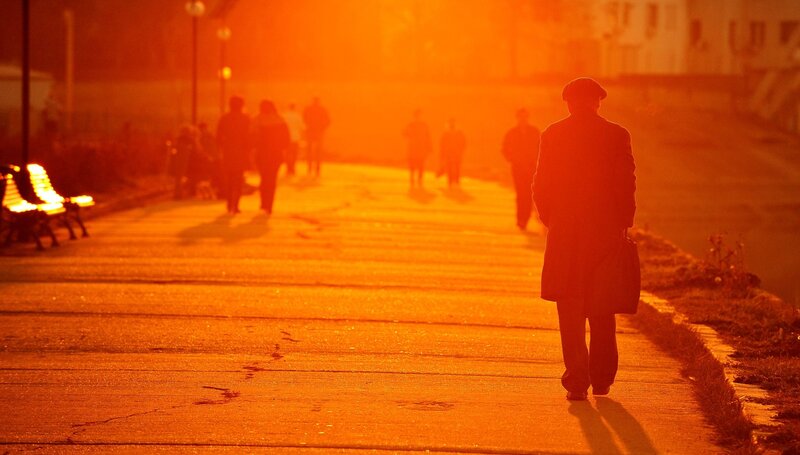 Man walking on a path at sunset