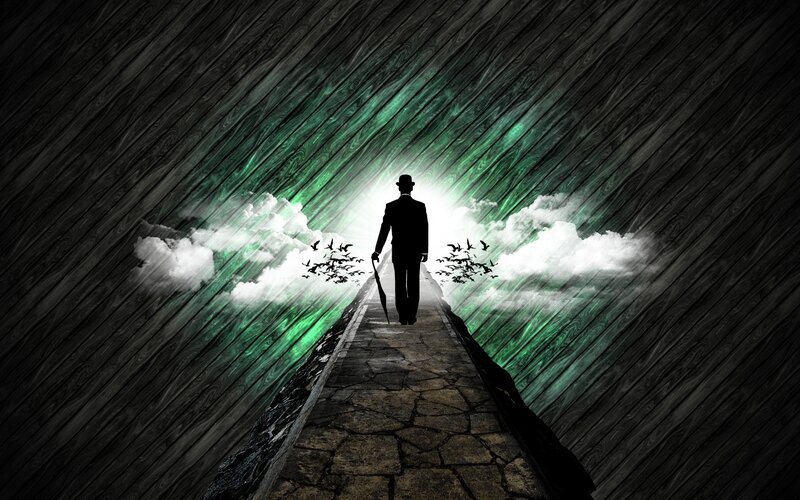 man walking on path to light