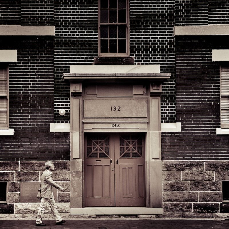 Man walking past a building entrance