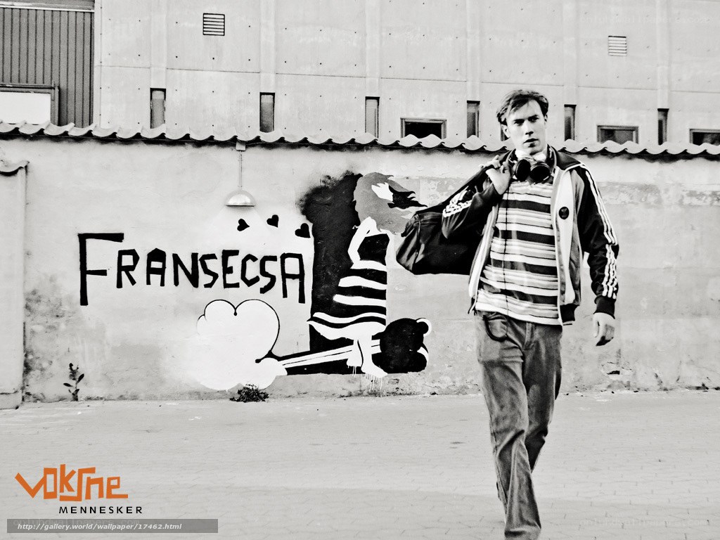 Man walking past graffiti wall