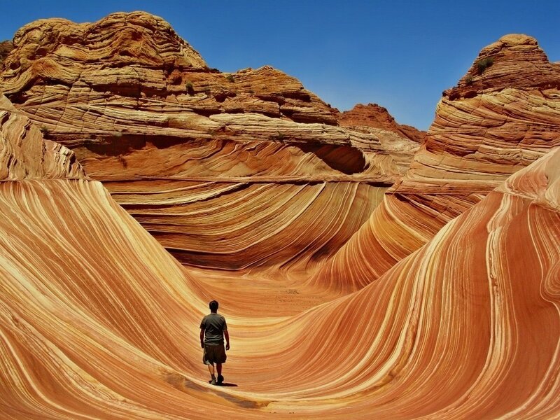 Man walking through sandstone waves