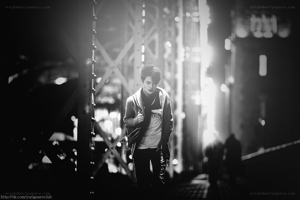 man walking under bridge at night
