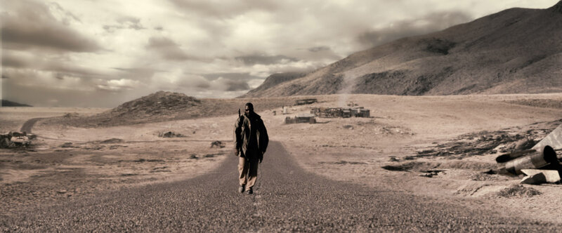 man walks on desert road
