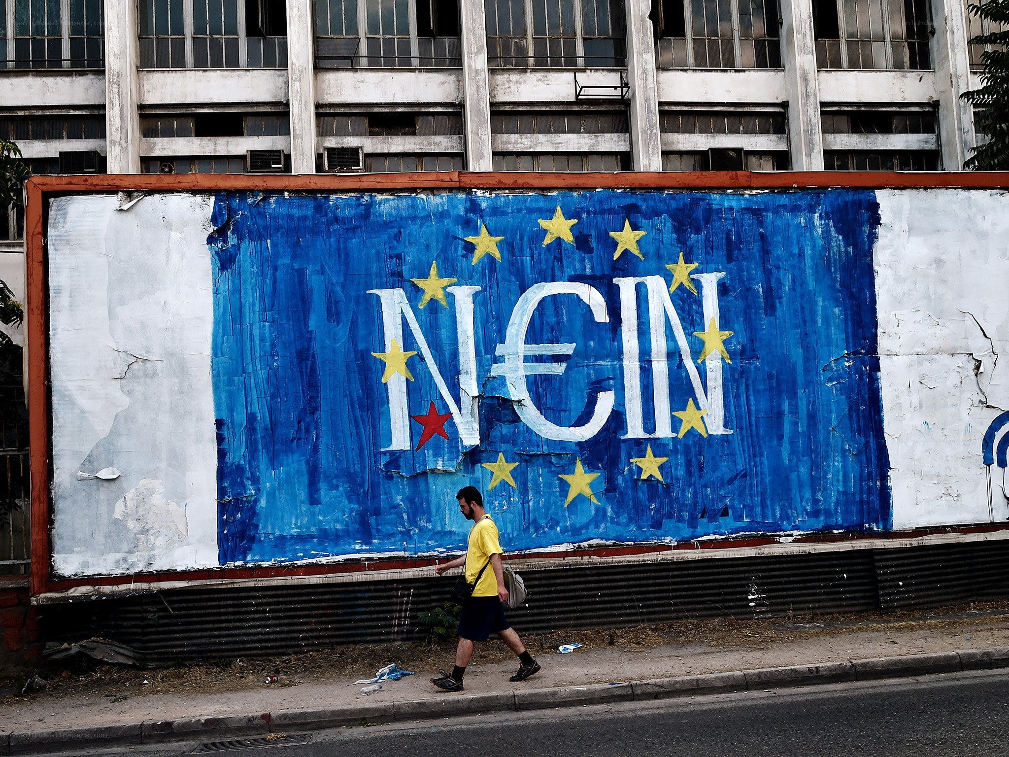 Man walks past EU graffiti