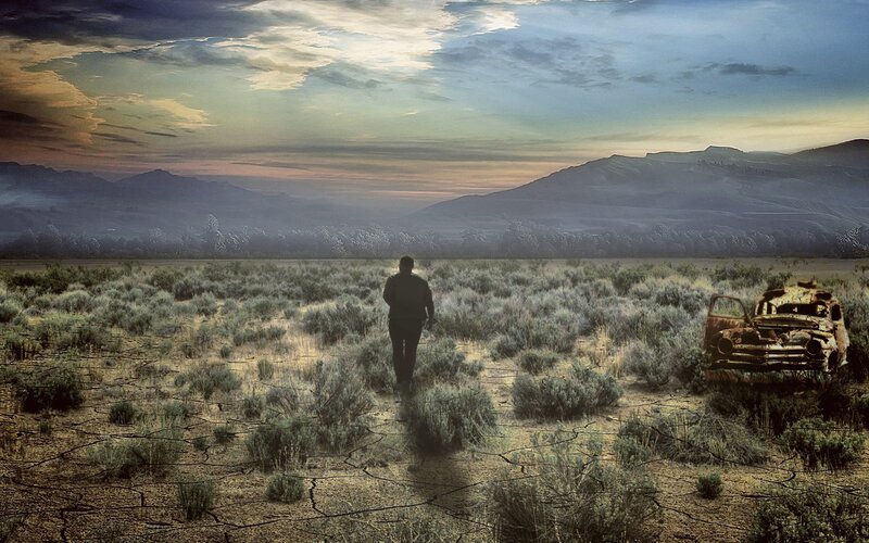 Man walks through desolate landscape
