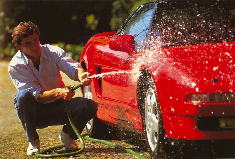 Man washing red sports car