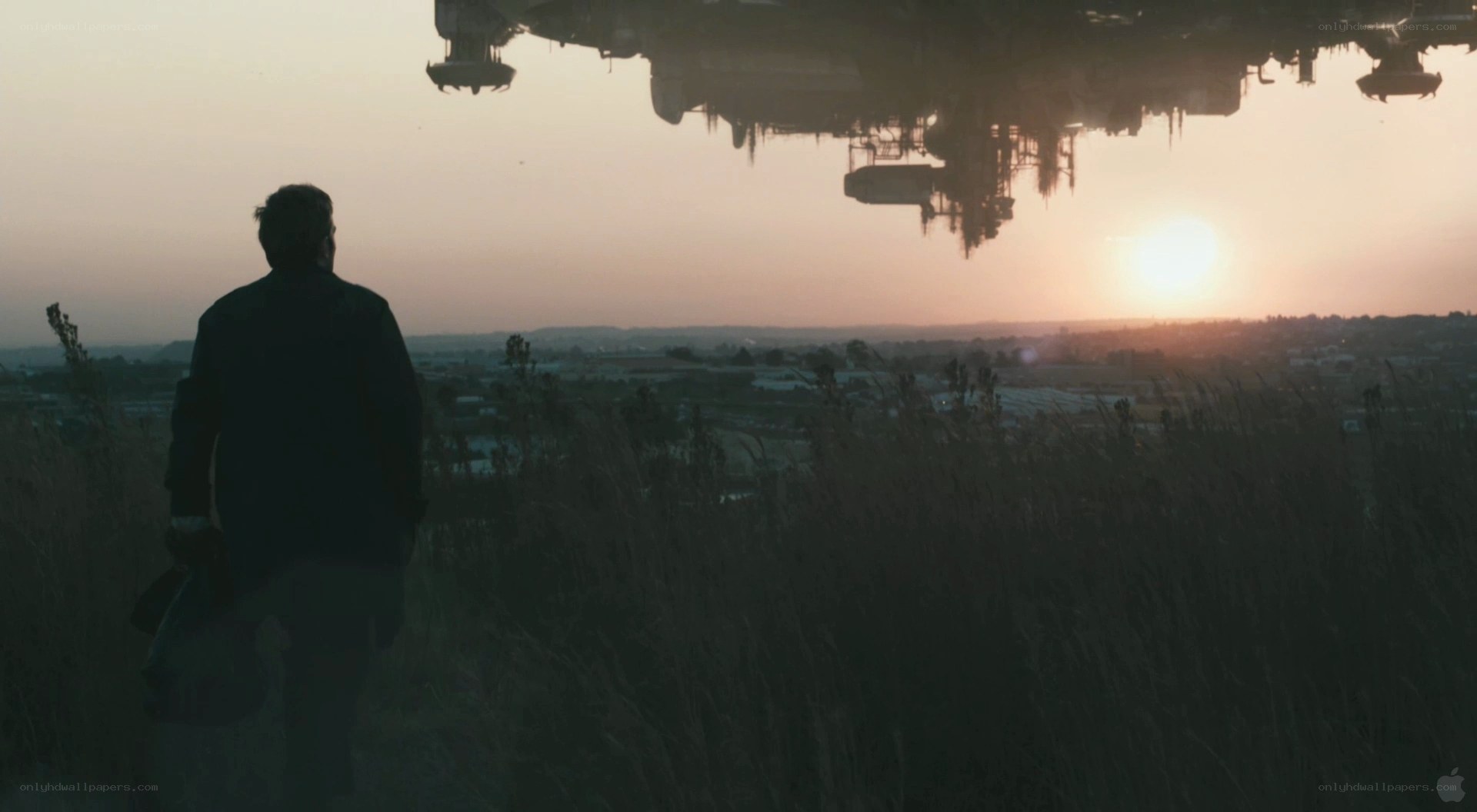 man watching alien ship at sunset