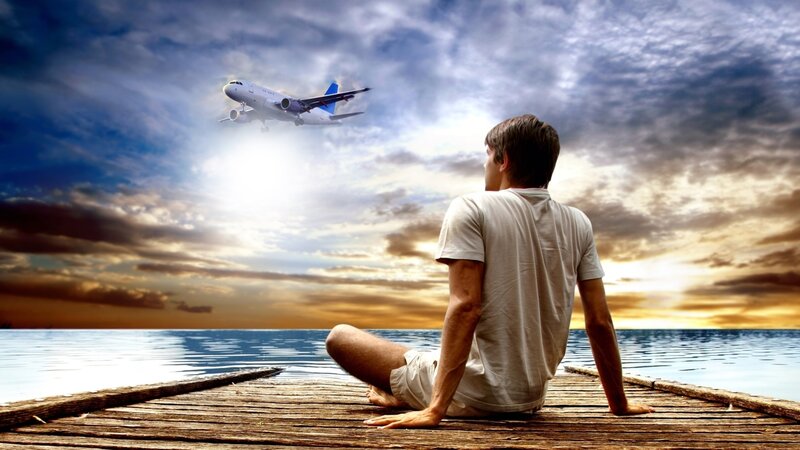 Man watching plane at sunset