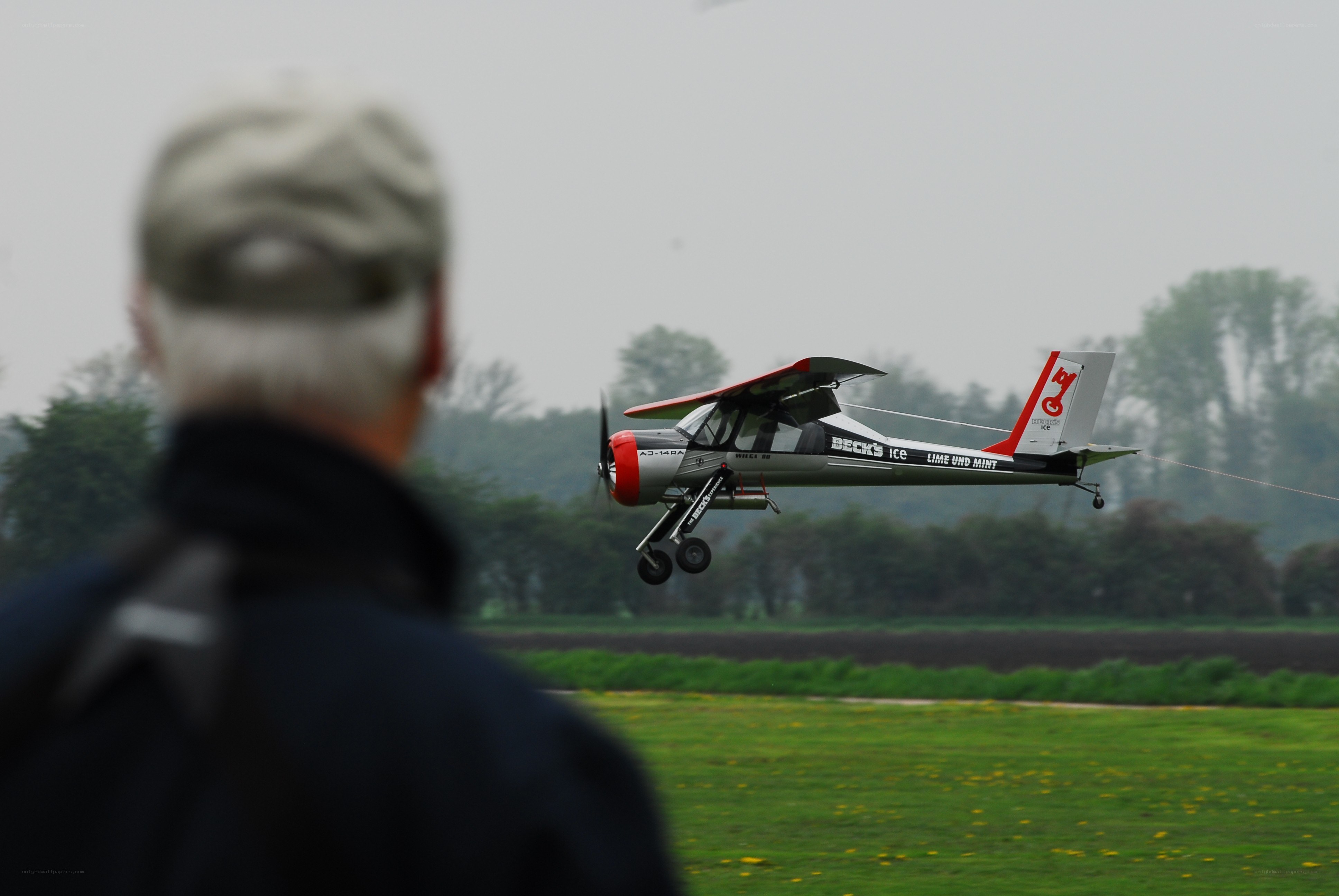 man watching small plane takeoff