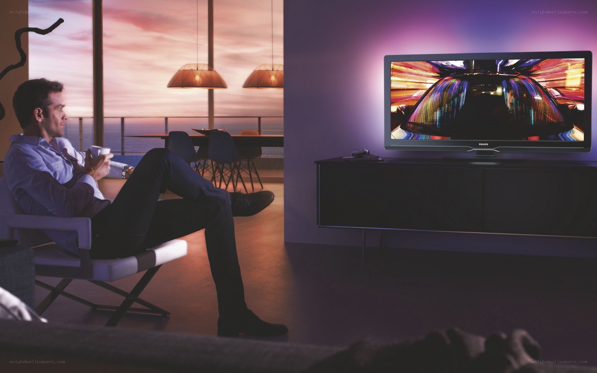 Man watching TV at sunset