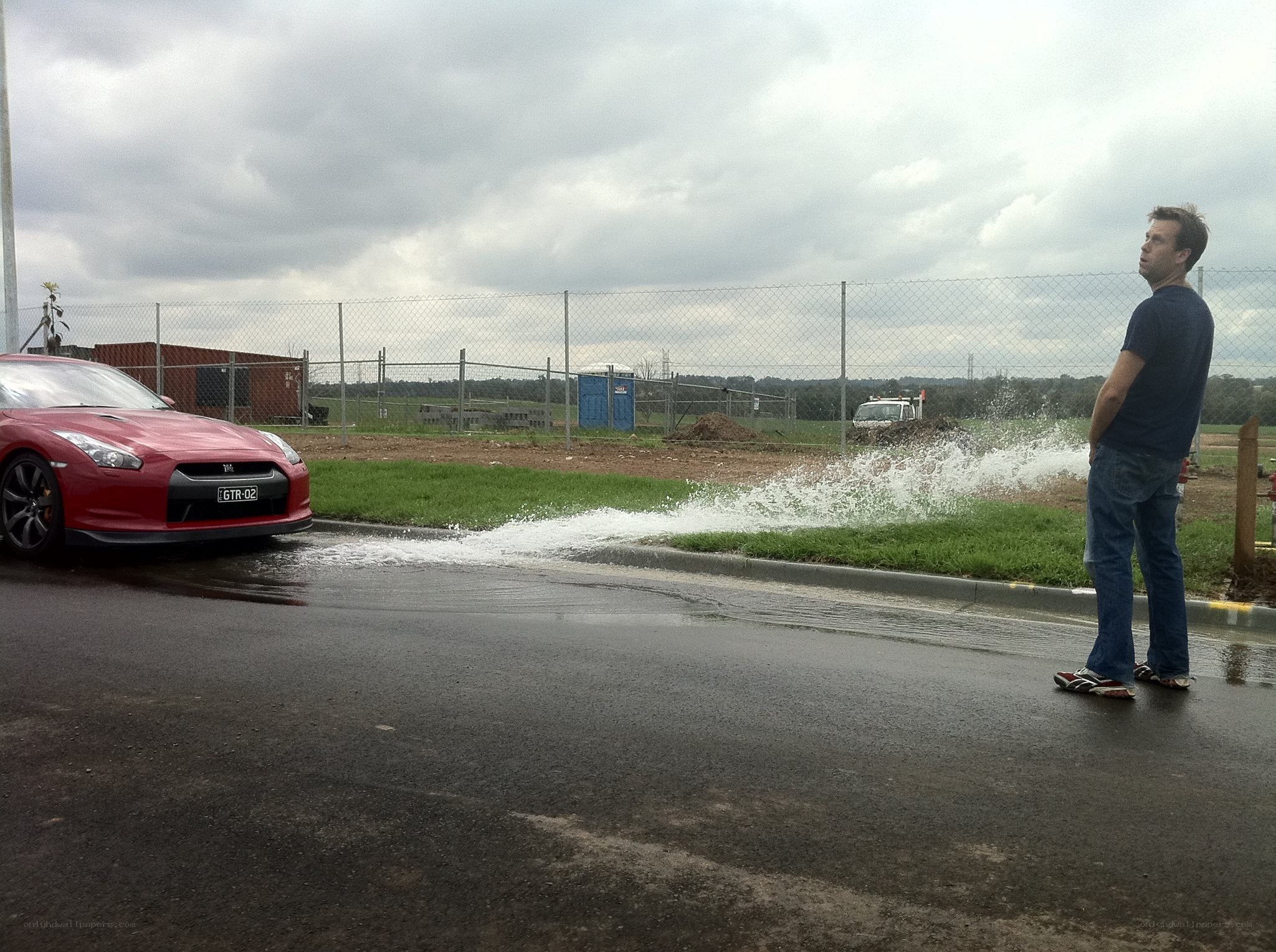 Man watching water spray from car