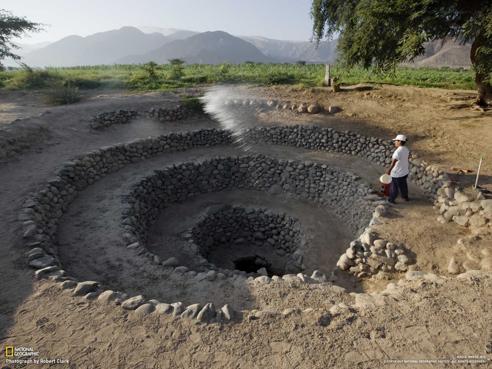 Man watering ancient well