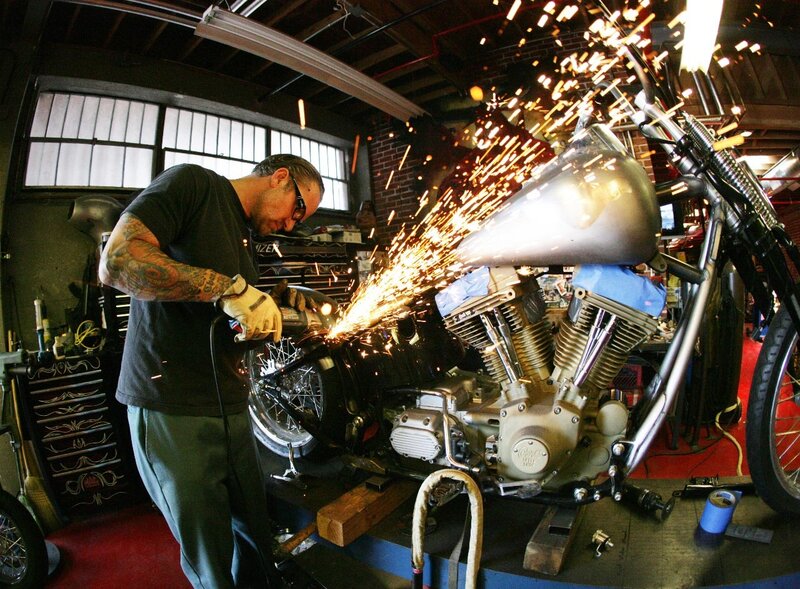 Man welding motorcycle in workshop