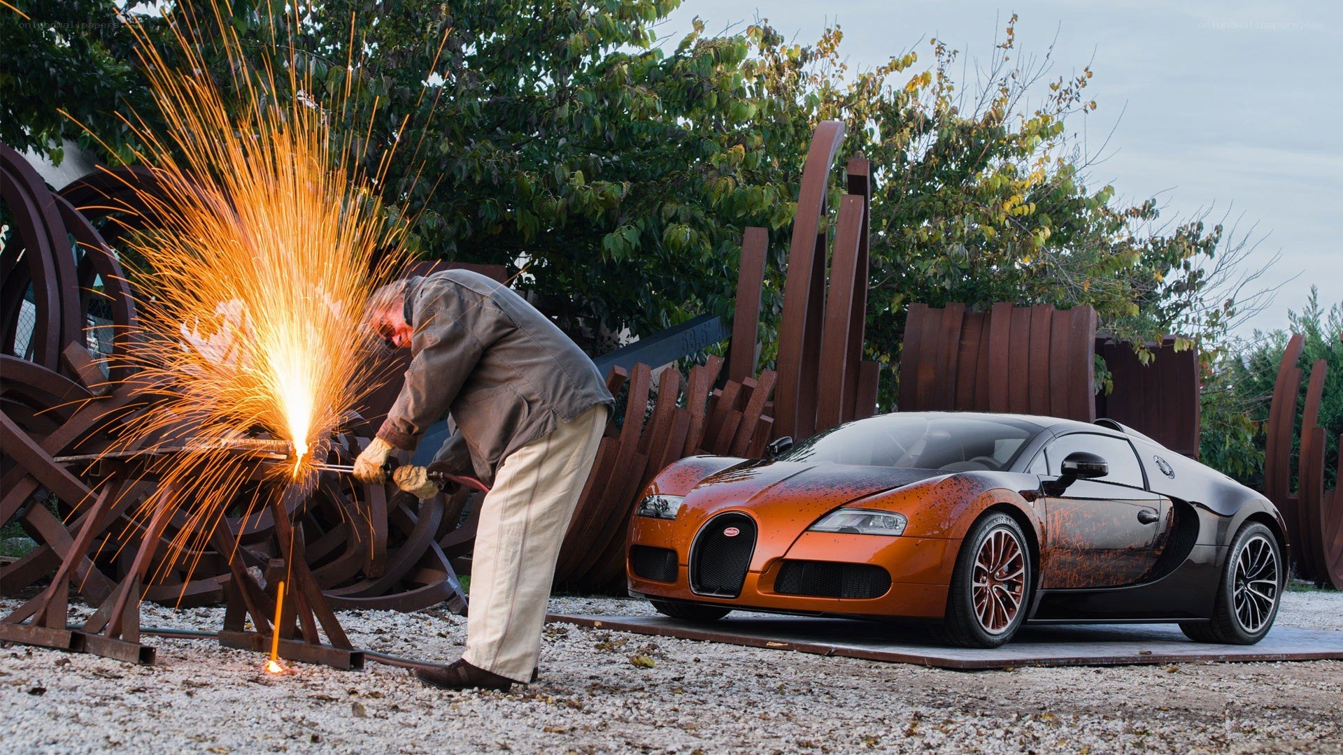 Man welding near Bugatti car