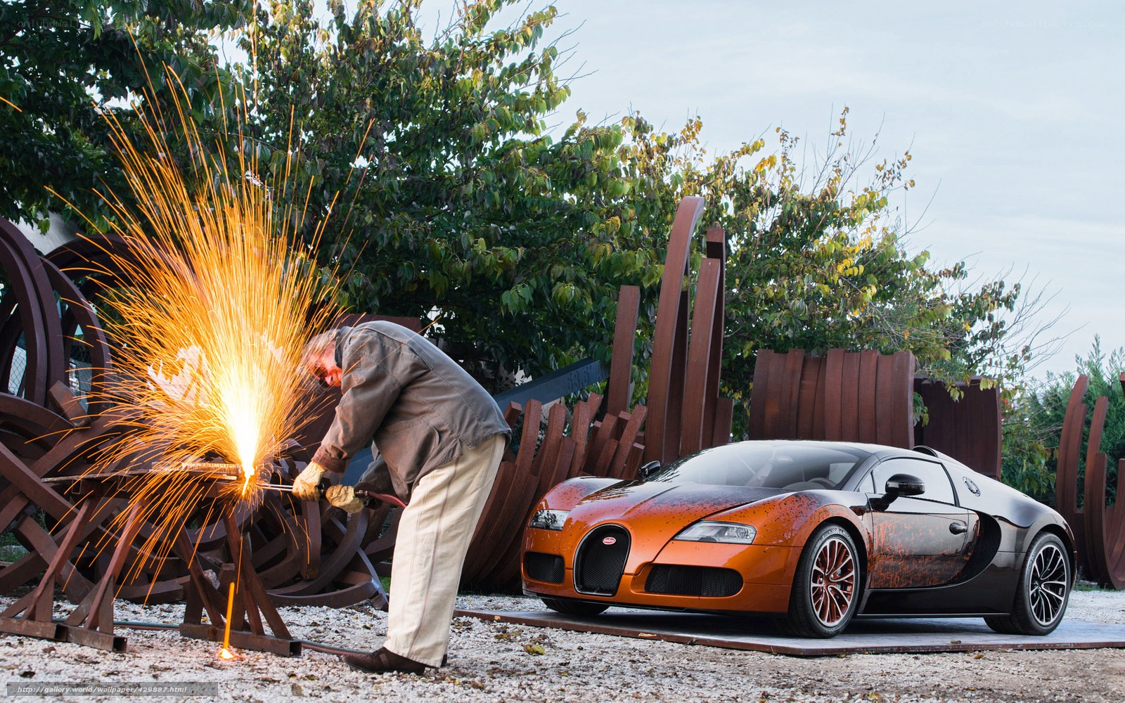 Man welding near Bugatti car