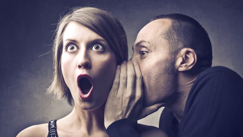 man whispering to woman