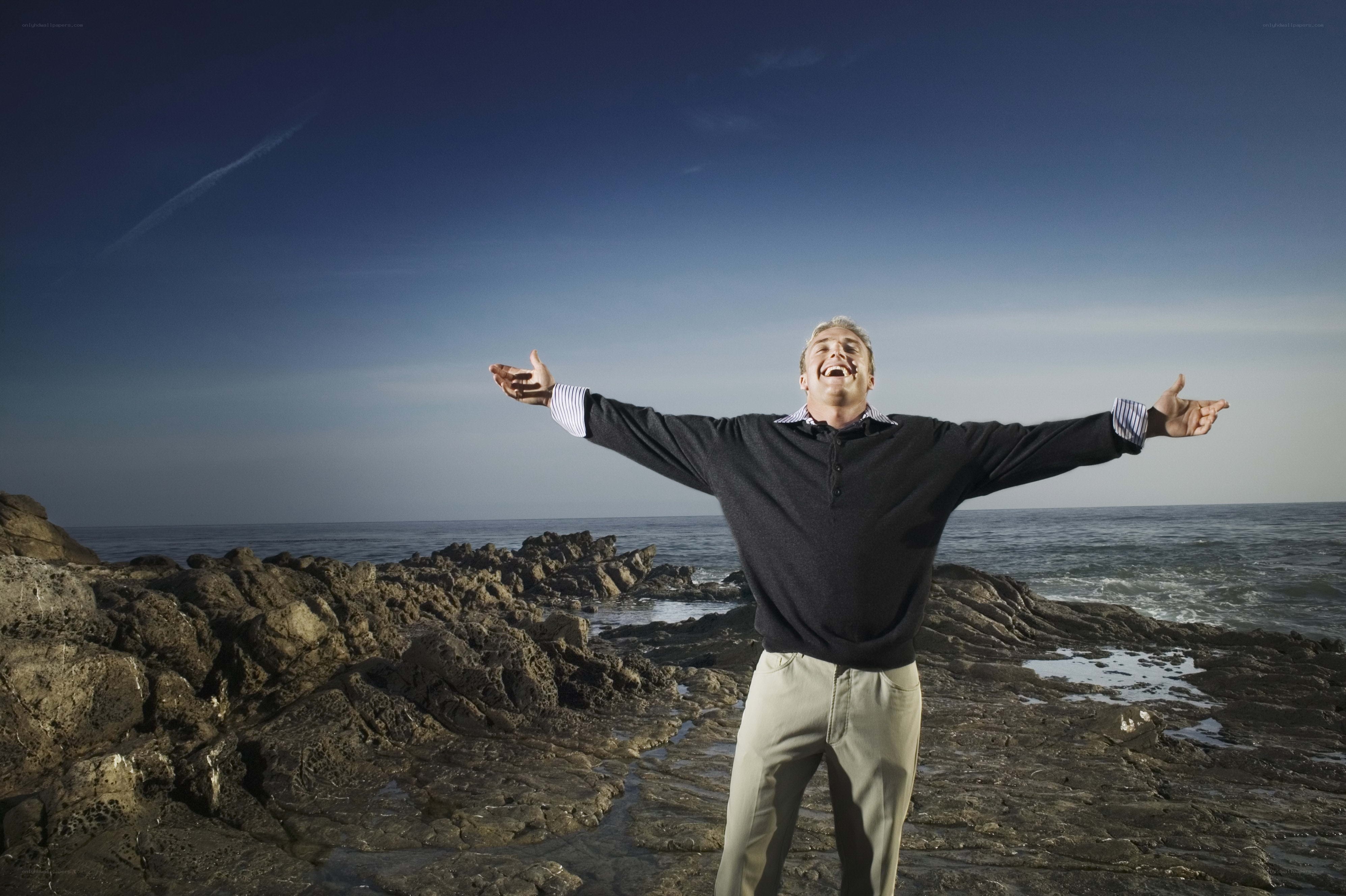 Man with arms outstretched at the beach