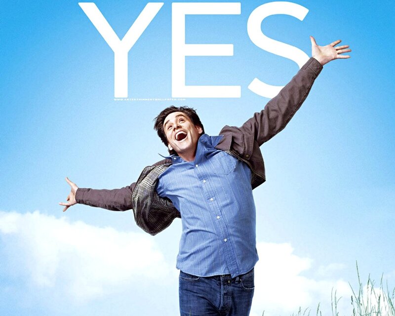 man with arms raised under blue sky