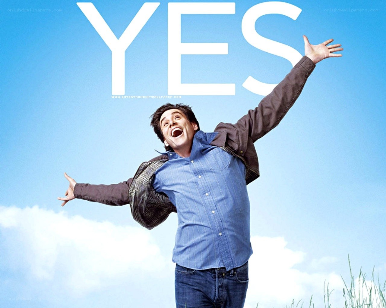 man with arms raised under blue sky