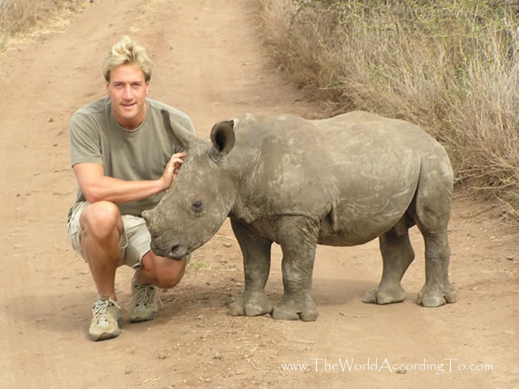 man with baby rhino