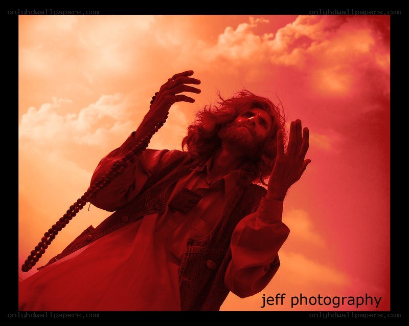 man with beads against red sky