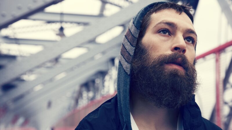 man with beard on bridge
