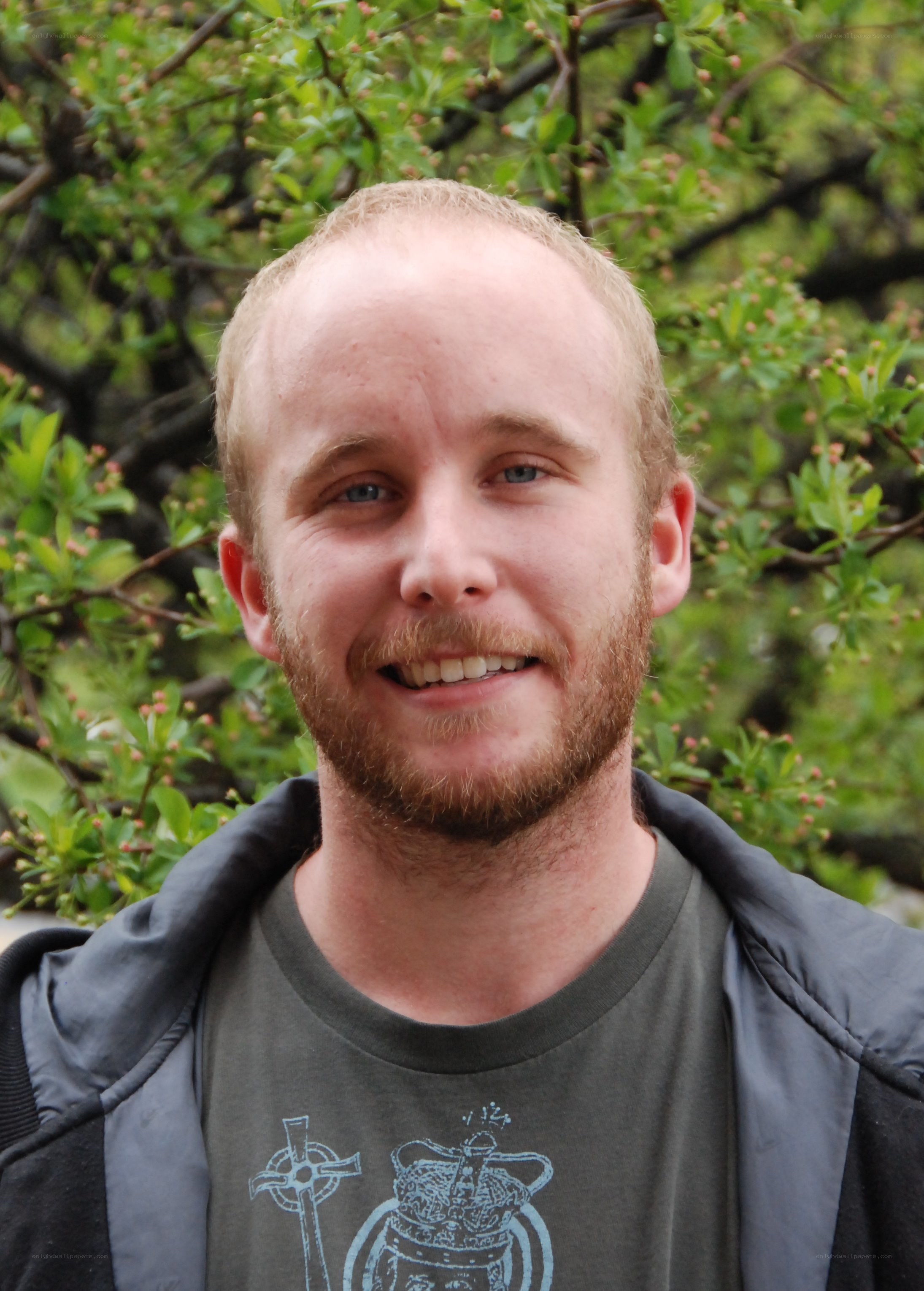 man with beard smiling outdoors