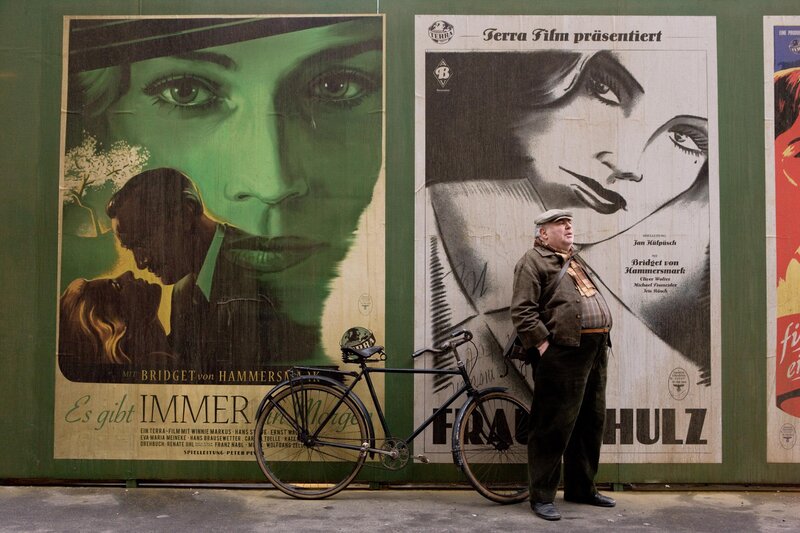 Man with bicycle by film posters
