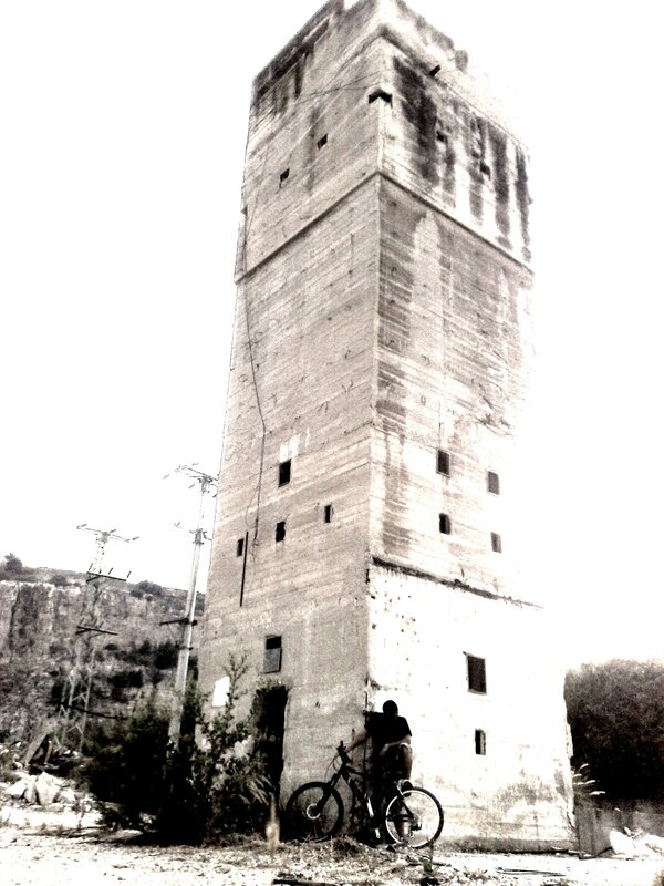 Man with bicycle near old tower