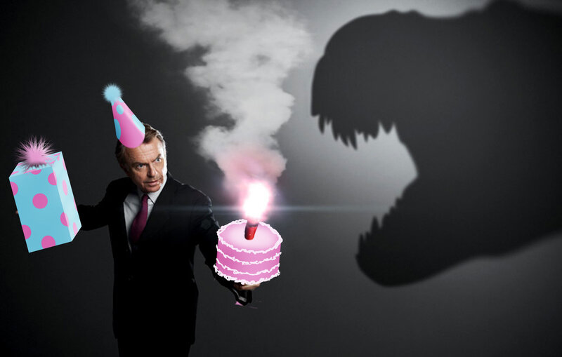 Man with birthday cake and dinosaur shadow