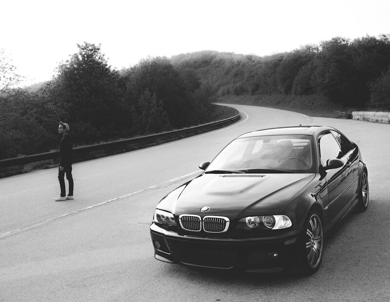 Man with black car on winding road