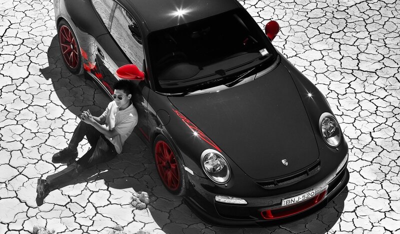 Man with black Porsche on cracked ground