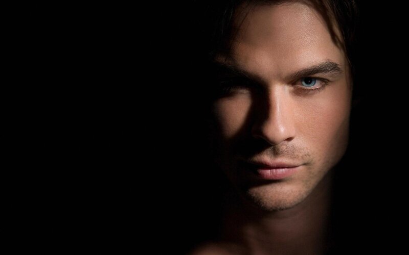 man with blue eyes in darkness