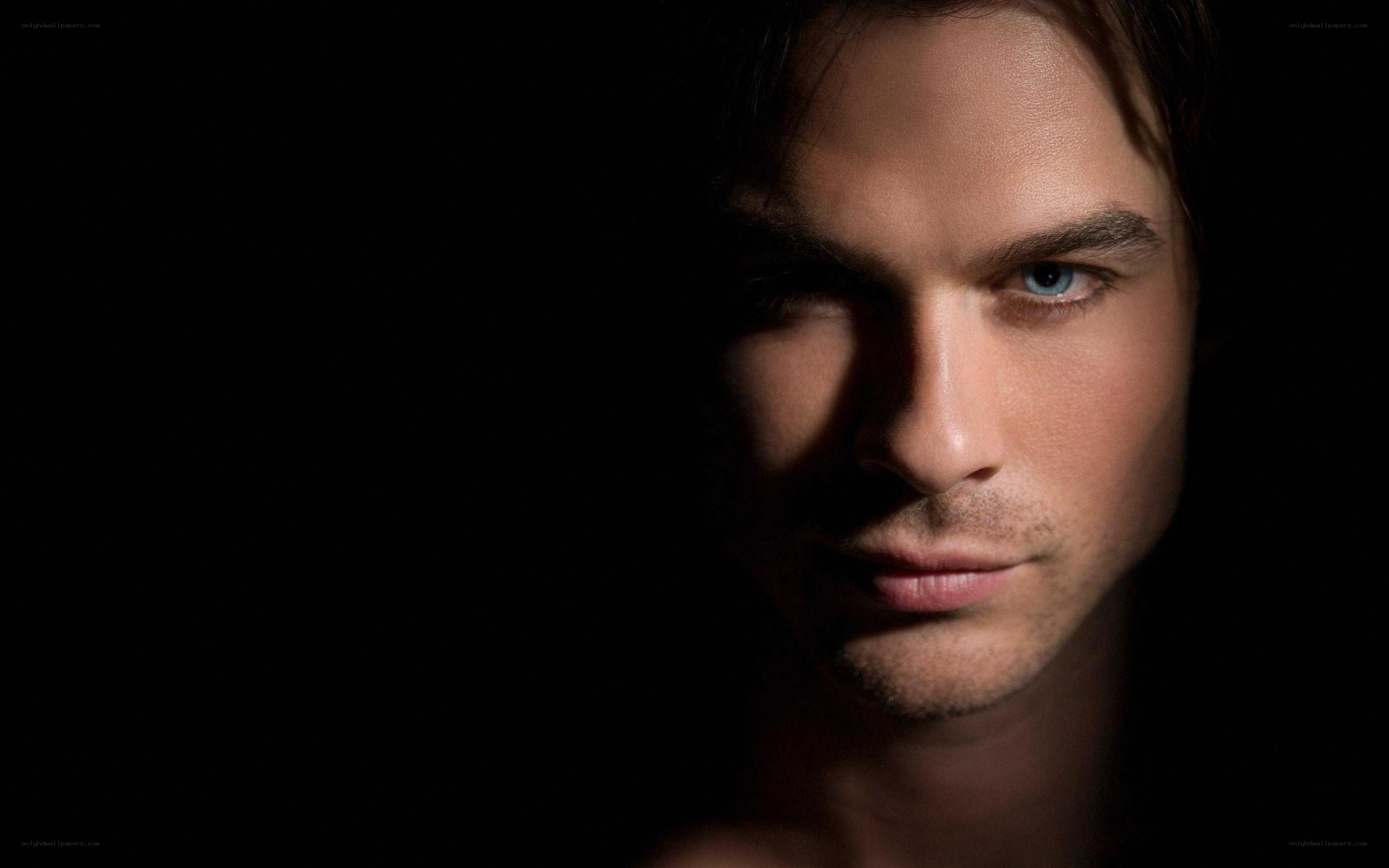 man with blue eyes in darkness