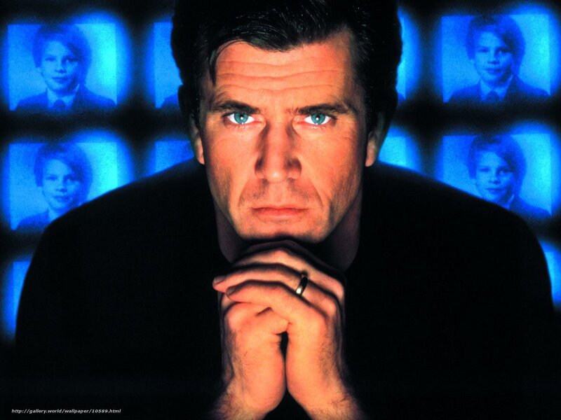 Man with blue eyes in front of screens