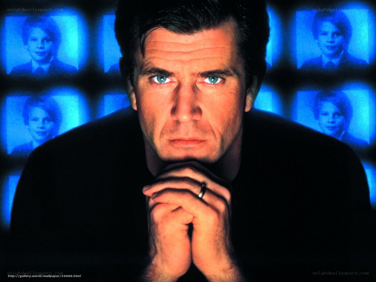 Man with blue eyes in front of screens
