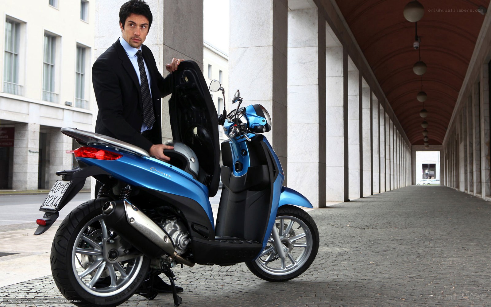Man with blue scooter in city