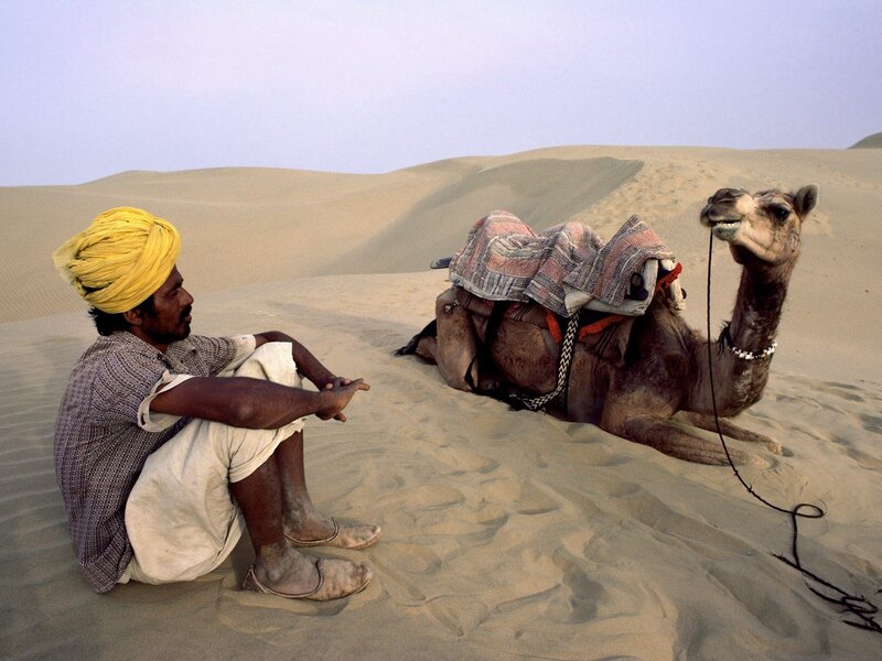 Man with camel in desert