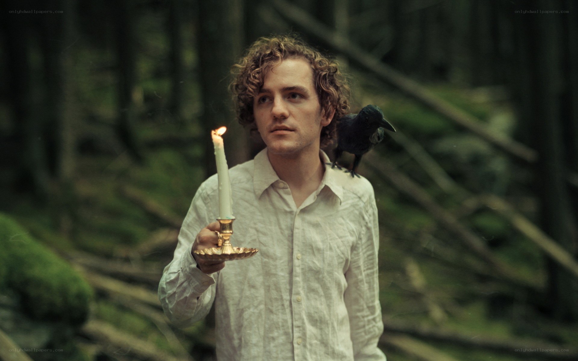 Man with candle in forest