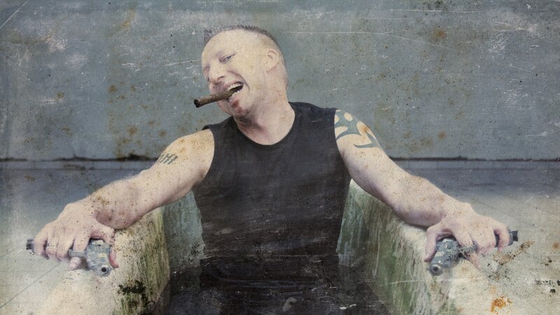 man with cigar and guns