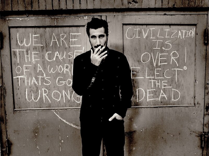 man with cigarette in front of graffiti