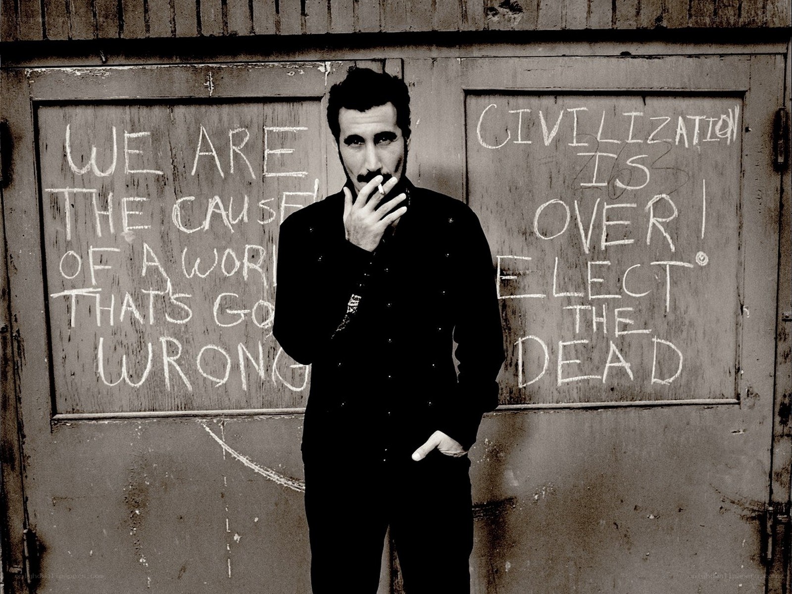 man with cigarette in front of graffiti