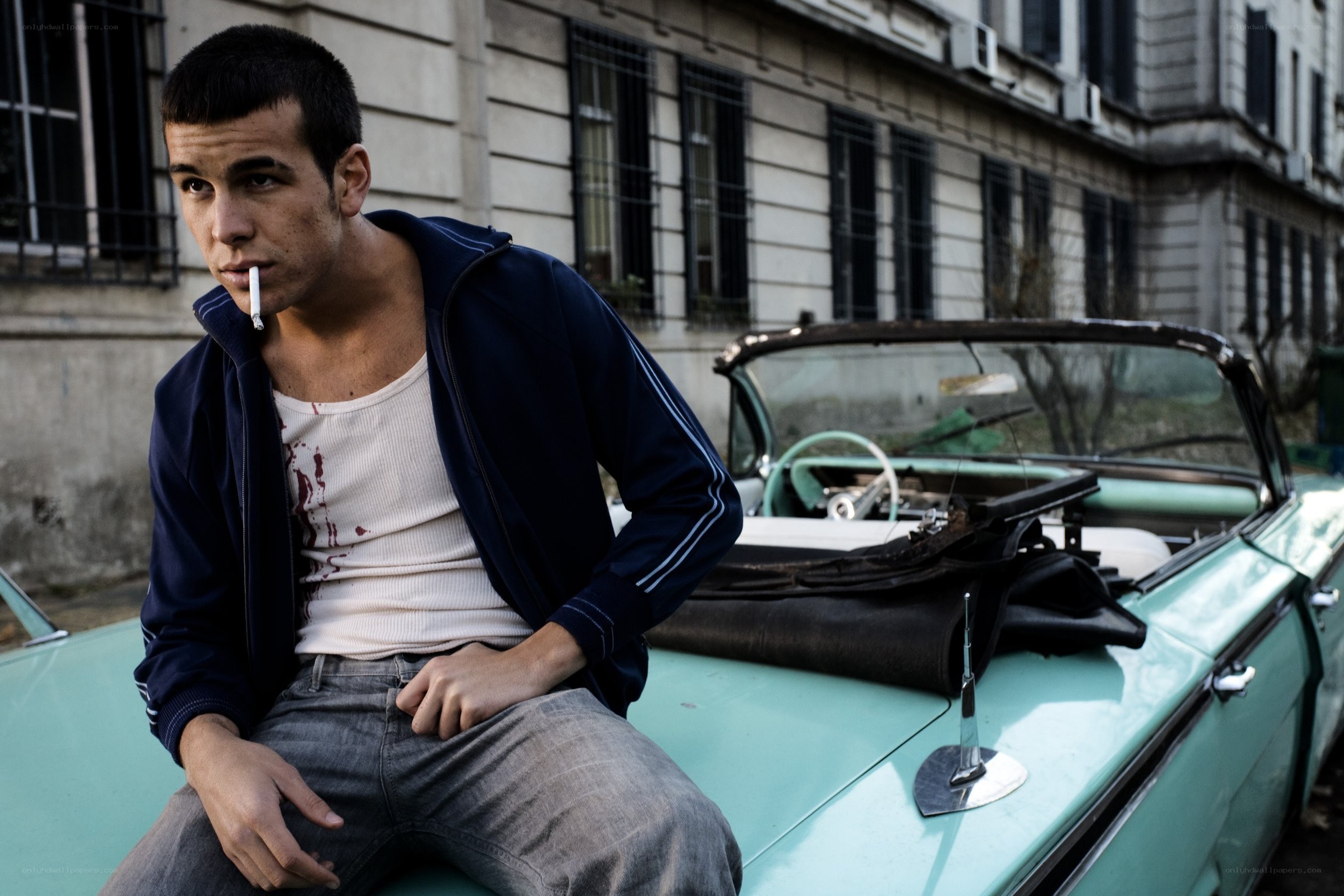 Man with cigarette on car hood
